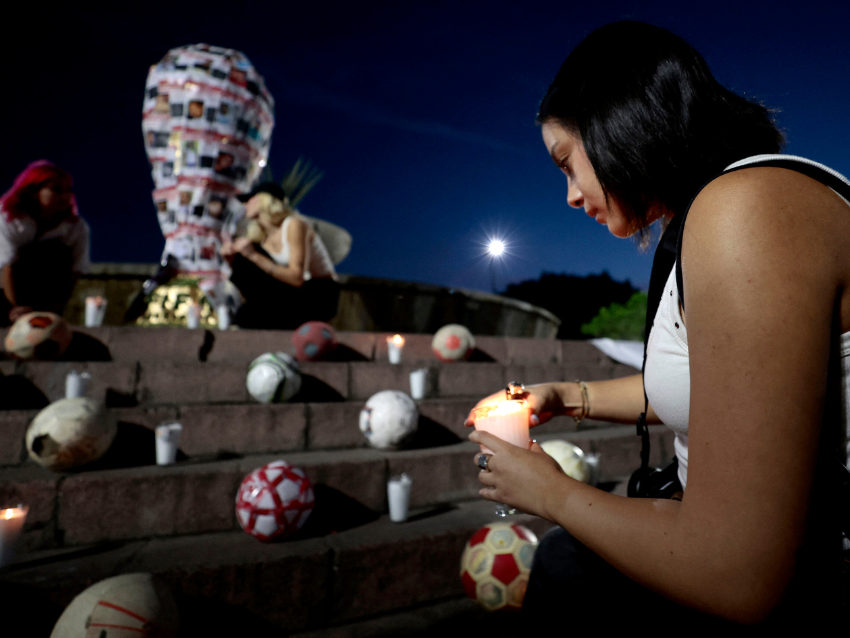 Un estudiante de la Universidad Jesuita de Guadalajara (ITESO) coloca una vela cerca de una réplica del trofeo de la Copa Mundial de la FIFA decorada con fotos de personas desaparecidas, durante una intervención artística con el colectivo "Luz y Esperanza" en Guadalajara, Jalisco, México, el 21 de noviembre de 2025. México será uno de los tres países anfitriones de la Copa Mundial 2026, y Jalisco albergará partidos de clasificación. (Foto de ULISES RUIZ / AFP vía Getty Images)